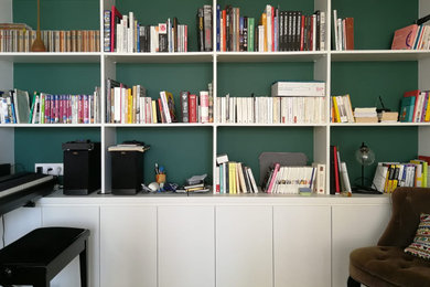 Ejemplo de sala de estar con biblioteca abierta contemporánea pequeña sin chimenea con paredes verdes, suelo de madera clara y suelo marrón