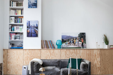 Источник вдохновения для домашнего уюта: большая открытая гостиная комната в современном стиле с с книжными шкафами и полками, белыми стенами и бетонным полом без камина