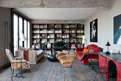 Modelo de sala de estar con biblioteca cerrada urbana de tamaño medio sin chimenea con paredes grises, suelo de madera oscura y televisor independiente
