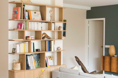 Inspiration pour une salle de séjour design de taille moyenne et ouverte avec une bibliothèque ou un coin lecture, un mur vert, parquet clair et un sol marron.