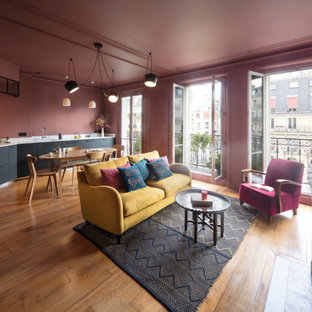 Idées déco pour une grand salle de séjour moderne ouverte avec un mur rose, un sol en bois brun, une cheminée standard et un sol beige.
