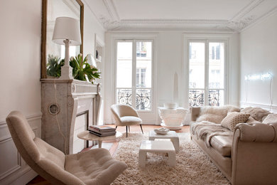 Fernseherloses Modernes Wohnzimmer mit weißer Wandfarbe, braunem Holzboden, Kamin und Kaminumrandung aus Stein in Paris