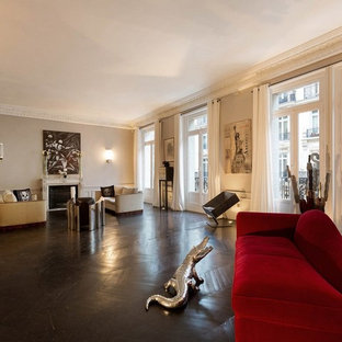 Idée de décoration pour une très grand salle de séjour design ouverte avec un mur beige, un sol en bois foncé, une cheminée standard et un manteau de cheminée en pierre.