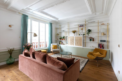 Diseño de sala de estar con biblioteca abierta contemporánea de tamaño medio sin chimenea con paredes verdes, suelo de madera oscura, televisor retractable y suelo marrón