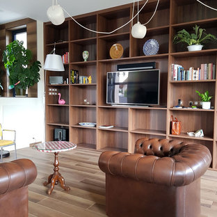 Idée de décoration pour une grand salle de séjour avec une bibliothèque ou un coin lecture ethnique ouverte avec un sol en bois clair, cheminée suspendue et un téléviseur indépendant.