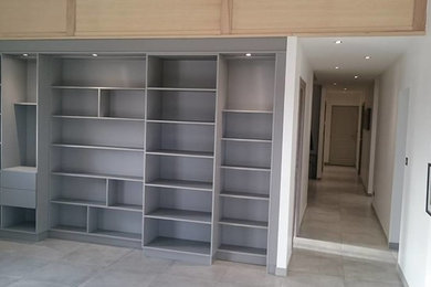 Exemple d'une petite salle de séjour moderne ouverte avec une bibliothèque ou un coin lecture et un mur gris.