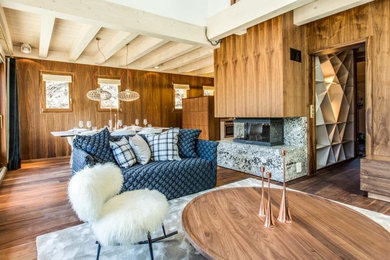 Inspiration pour une grande salle de séjour chalet ouverte avec un mur marron, un sol en bois brun, un sol marron, un poêle à bois et un manteau de cheminée en pierre.