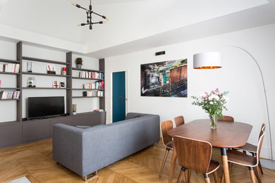 Cette image montre une salle de séjour design de taille moyenne et ouverte avec un mur blanc, un sol en bois brun, aucune cheminée, un téléviseur indépendant et un sol marron.
