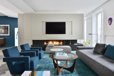 На фото: большая открытая гостиная комната в современном стиле с белыми стенами, горизонтальным камином, телевизором на стене и ковром на полу