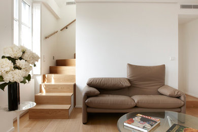 Ejemplo de sala de estar abierta contemporánea de tamaño medio sin televisor con paredes blancas y suelo de madera en tonos medios