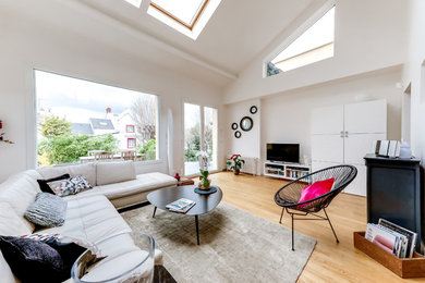 Exemple d'une salle de séjour tendance de taille moyenne et ouverte avec un mur blanc, parquet clair, un téléviseur indépendant et un sol beige.