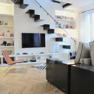Foto di un soggiorno minimal di medie dimensioni e aperto con pareti bianche, parquet chiaro e TV a parete