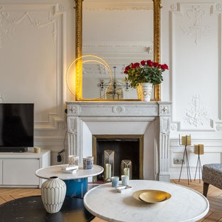 Réalisation d'une salle de séjour design de taille moyenne et fermée avec un mur blanc, un sol en bois brun, une cheminée standard, un manteau de cheminée en pierre et un téléviseur indépendant.