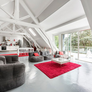Réalisation d'une grand salle de séjour design avec un mur blanc, béton au sol, aucune cheminée et aucun téléviseur.