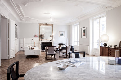 Immagine di un grande soggiorno design aperto con pareti bianche, pavimento in legno massello medio e camino classico