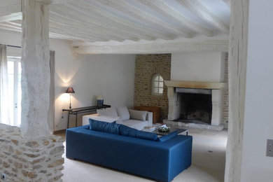 Inspiration pour une salle de séjour traditionnelle de taille moyenne et ouverte avec un mur blanc, une cheminée standard et un sol blanc.