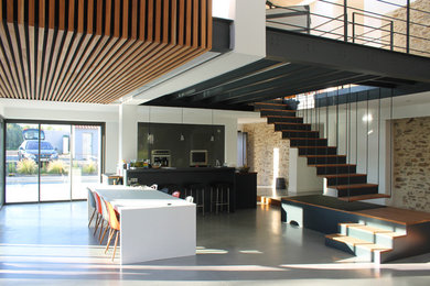 Large contemporary mezzanine games room in Nantes with white walls, concrete flooring, a concealed tv and white floors.