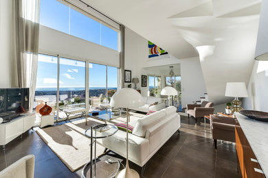 Foto de sala de estar tipo loft contemporánea grande con paredes blancas, suelo de cemento, televisor independiente y suelo gris
