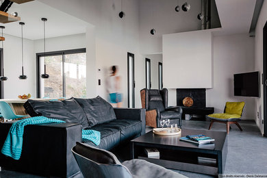 Diseño de sala de estar abierta actual con suelo de baldosas de cerámica, todas las chimeneas, marco de chimenea de hormigón y televisor colgado en la pared