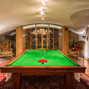 Réalisation d'une salle de séjour méditerranéenne avec salle de jeu, un mur beige, un sol en bois brun et un sol marron.