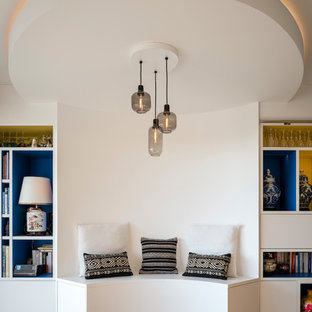 Exemple d'une grand salle de séjour avec une bibliothèque ou un coin lecture asiatique ouverte avec un mur blanc, un sol en bois brun, aucune cheminée et un téléviseur dissimulé.