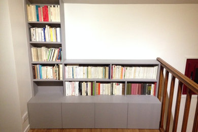 Modelo de sala de estar con biblioteca tipo loft actual de tamaño medio sin televisor con paredes blancas y suelo laminado