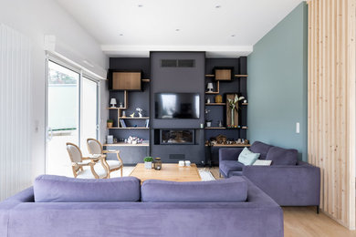 Cette photo montre une salle de séjour tendance avec un mur multicolore, parquet clair, cheminée suspendue, un manteau de cheminée en métal et un téléviseur fixé au mur.