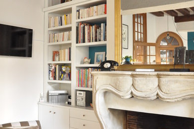 Foto di un grande soggiorno boho chic aperto con libreria, pareti bianche, pavimento in legno massello medio e TV a parete