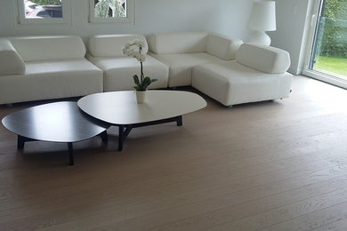 Ejemplo de sala de estar abierta contemporánea grande con paredes blancas y suelo de madera clara
