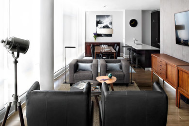 Стильный дизайн: открытая гостиная комната среднего размера в стиле модернизм с серыми стенами, паркетным полом среднего тона и телевизором на стене - последний тренд