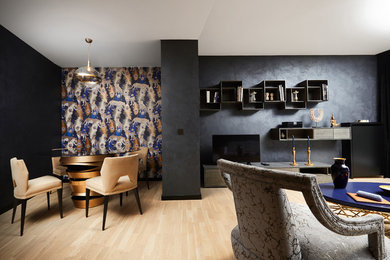 Idée de décoration pour une salle de séjour design de taille moyenne et fermée avec un mur noir, parquet clair, un téléviseur indépendant et un sol marron.