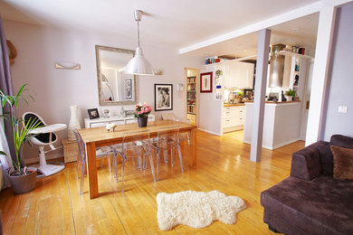 Cette image montre une grande salle de séjour minimaliste ouverte avec un mur blanc, parquet clair, aucune cheminée, un téléviseur indépendant et un sol marron.