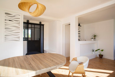 Foto de sala de estar abierta costera de tamaño medio con paredes blancas y suelo de madera clara