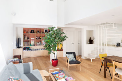 Свежая идея для дизайна: открытая гостиная комната в стиле модернизм с с книжными шкафами и полками и светлым паркетным полом - отличное фото интерьера