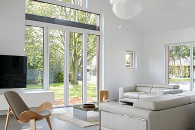 Пример оригинального дизайна: открытая гостиная комната среднего размера в скандинавском стиле с белыми стенами, полом из керамической плитки, телевизором на стене и серым полом без камина