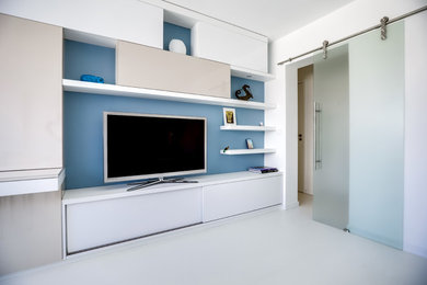На фото: большая открытая гостиная комната в стиле модернизм с синими стенами, деревянным полом, отдельно стоящим телевизором и белым полом без камина с