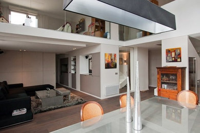 Diseño de sala de estar abierta de tamaño medio con paredes beige, suelo de madera clara y suelo beige