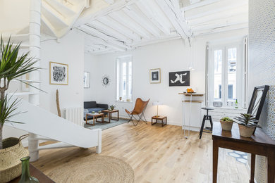 Idées déco pour une salle de séjour scandinave de taille moyenne et ouverte avec un mur blanc, parquet clair et un sol marron.