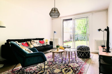 Foto de sala de estar abierta bohemia de tamaño medio sin chimenea con paredes blancas, suelo de madera clara, televisor independiente y suelo marrón