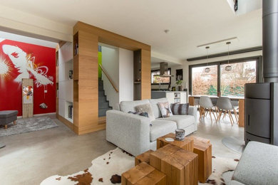 Exemple d'une grande salle de séjour ouverte avec un mur blanc, sol en béton ciré, un poêle à bois et un sol gris.