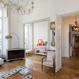 Cette photo montre une salle de séjour chic ouverte avec un mur blanc, un sol en bois brun et un téléviseur indépendant.