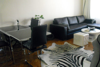Immagine di un soggiorno contemporaneo di medie dimensioni e chiuso con pareti bianche, parquet chiaro e TV autoportante