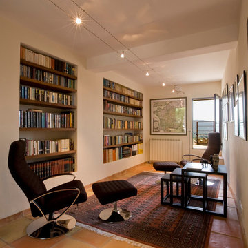 Salon de lecture et bibliothèque dans maison de village provençal