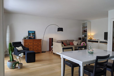 Cette photo montre une grande salle de séjour tendance avec un mur blanc, parquet clair et un sol marron.