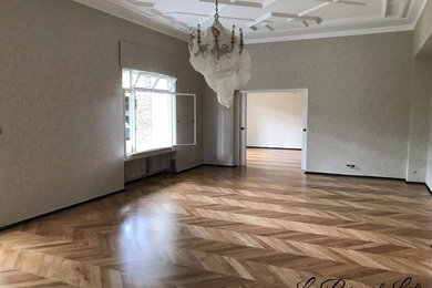 Aménagement d'une très grande salle de séjour classique ouverte avec un mur blanc, parquet clair et un sol beige.