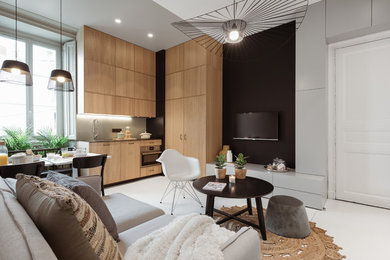 Imagen de sala de estar abierta actual con paredes negras, suelo de madera pintada, televisor colgado en la pared y suelo blanco