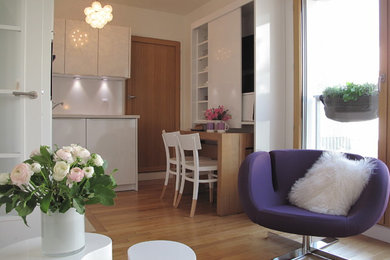 Idée de décoration pour une petite salle de séjour design ouverte avec un mur blanc, un sol en bois brun, aucune cheminée et aucun téléviseur.