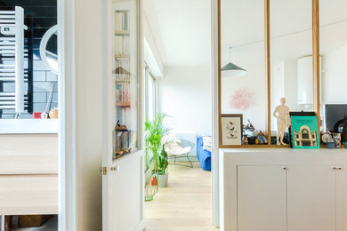 Mittelgroßes, Fernseherloses, Abgetrenntes Modernes Wohnzimmer ohne Kamin mit weißer Wandfarbe, hellem Holzboden und braunem Boden in Paris