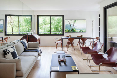 Idées déco pour une salle de séjour contemporaine ouverte avec un mur blanc, parquet clair, aucune cheminée et un téléviseur fixé au mur.