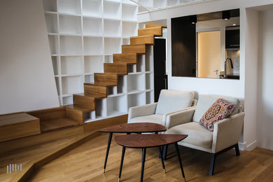 Foto de sala de estar tipo loft actual con suelo de madera en tonos medios y suelo marrón